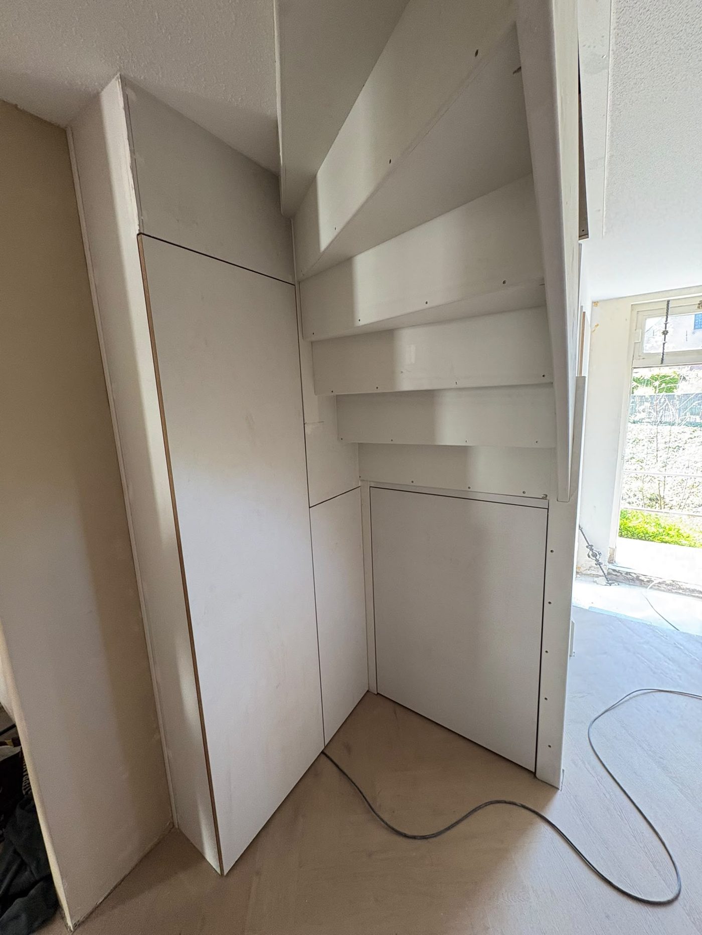 Schuine wand met deur en wasmachine-opstelling
